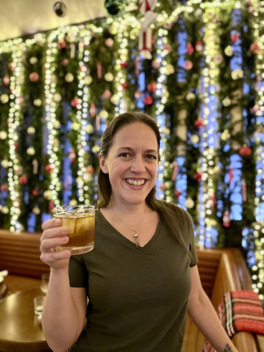 woman sipping a cocktail at the Jingle Jangle holiday event at the Rooftop at Pier 17 in NYC